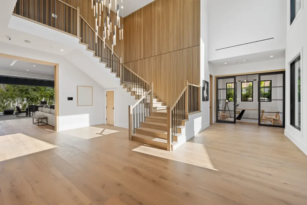 Intérieur de maison moderne avec escalier en bois et grandes fenêtres