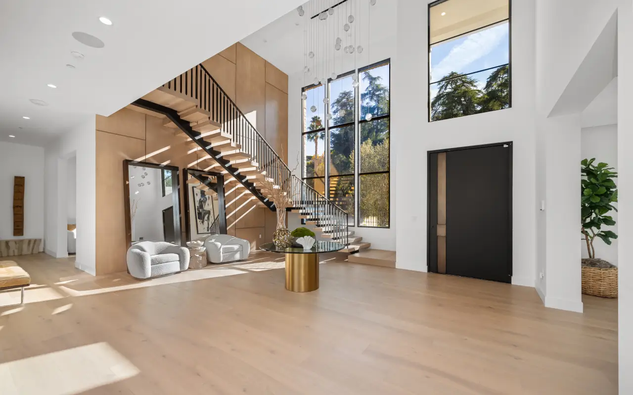 un très grand salon agréable avec du parquet et des escaliers